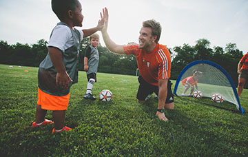 child giving high 5 with coach